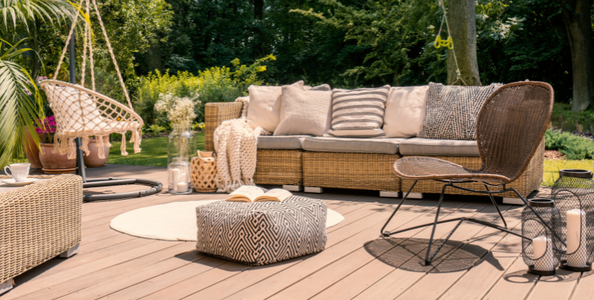 Small patio furniture with pillows, cushions and a wicker hanging chair.